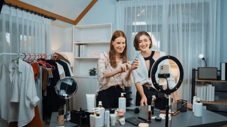 Photo for Two women influencer partner shoot live streaming vlog video review skincare for prim social media or blog. Young girl with cosmetic studio lighting for marketing recording session broadcasting online - Royalty Free Image