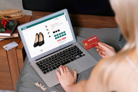 Photo for Young woman using laptop with credit card for internet banking, online shopping E commerce by online payment gateway at home. Modern and convenience online shopping with debit card. Blithe - Royalty Free Image