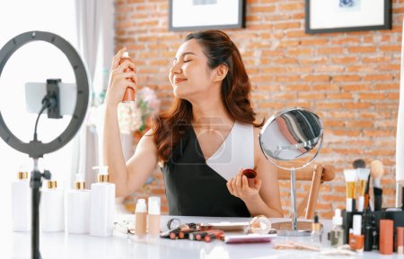 Photo for Woman influencer shoot live streaming vlog video review makeup uttermost social media or blog. Happy young girl with cosmetics studio lighting for marketing recording session broadcasting online. - Royalty Free Image