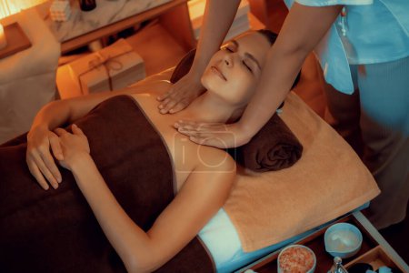 Téléchargez les photos : Femme caucasienne client appréciant relaxant massage spa anti-stress et dorloter avec beauté loisirs de la peau dans la bougie chaude éclairage spa salon d'ambiance à la station de luxe ou hôtel. Tranquillité - en image libre de droit