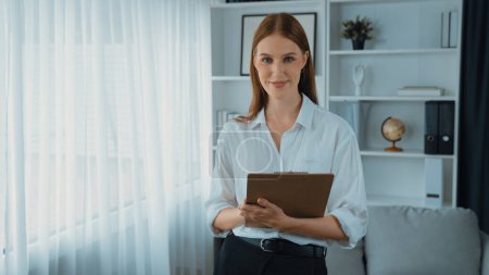 Photo for Friendly psychologist woman in clinic office professional portrait with smile and holding clipboard for patient to visit psychologist. The experienced and prim confident psychologist - Royalty Free Image