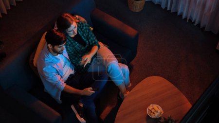 Photo for Top view of happy caucasian father and relaxed mother watching TV together while dad holding remote and changing channel. Smart family spend time together while enjoy talking about movie. Convocation. - Royalty Free Image
