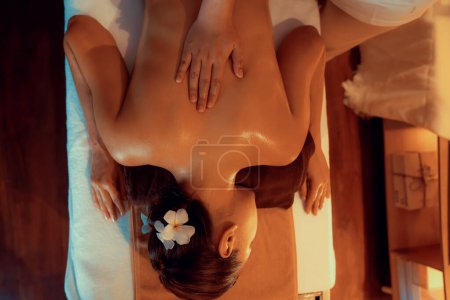 Téléchargez les photos : Top vue femme client profitant de détente anti-stress massage spa et dorloter avec beauté loisirs de la peau dans la bougie chaude éclairage spa salon d'ambiance au complexe de luxe ou hôtel. Tranquillité - en image libre de droit