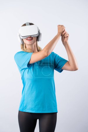 Photo for Caucasian girl playing golf and moving gesture by using VR glasses. Happy sport gamer with casual cloth playing game while wearing visual reality headset and standing at pink background. Contraption. - Royalty Free Image