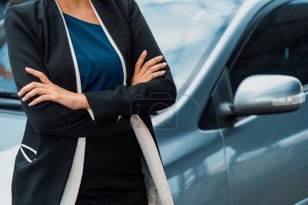 Photo for Confident professional business woman standing beside the car. Concept of car rental business and sales occupation. uds - Royalty Free Image