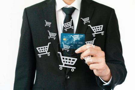 Photo for Elegant customer wear black suit and tie hold credit card, cashless technology, by left hand. Smart consumer use hologram graphic interface of e-commerce application platform around hands. Cybercash. - Royalty Free Image