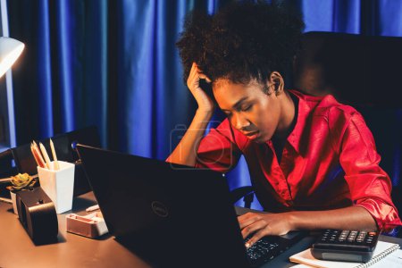 Jeune femme d'affaires africaine épuisée et endormie faisant une sieste dans son bras sur le bureau au bureau à la maison. Concept de penser beaucoup de projets jusqu'à dormir parmi le travail en ligne inachevé. Tastemaker.