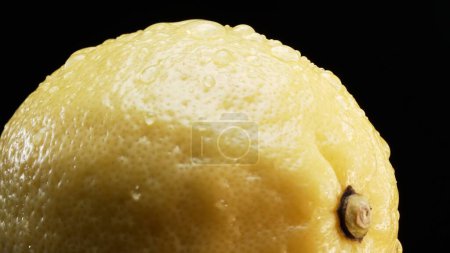 Téléchargez les photos : Macrographie, la texture complexe d'un citron frais sur un fond noir audacieux prend le devant de la scène. Chaque gros plan capture les motifs et les détails uniques de la surface des citrons. Comestible. - en image libre de droit