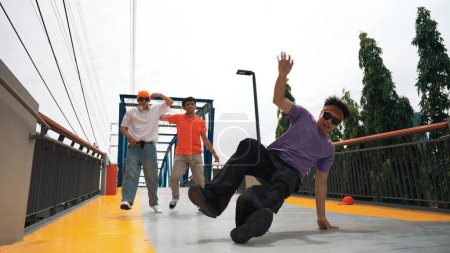 Photo for Panorama shot of hipster wearing stylish cloth and doing freeze pose. Group of professional dancer perform break dance while the outstanding man practice b-boy dancing. Outdoor sport 2024. Sprightly - Royalty Free Image