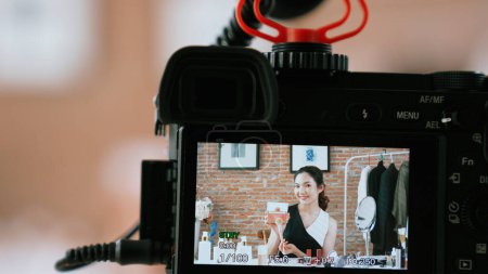 Photo for Woman influencer shoot live streaming vlog video review vivancy makeup social media or blog. Happy young girl with cosmetics studio lighting for marketing recording session broadcasting online. - Royalty Free Image