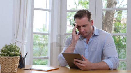 Homme d'affaires luttent pour résoudre le problème de travail de la maison en utilisant un ordinateur portable, assis sur son bureau au bureau à la maison avec l'expression stressée et frustrée, en essayant de trouver une solution pour le problème. Synchronos