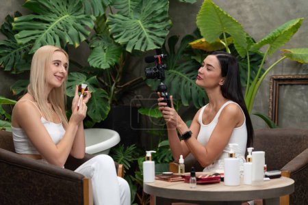Photo for Two beautiful content creator making natural beauty and cosmetic tutorial on green plant garden video. Beauty blogger showing how to beauty care to social medial audience using selfie stick . Blithe - Royalty Free Image