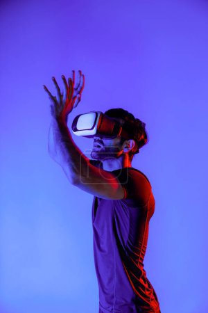 Foto de Hombre caucásico jugando baloncesto mientras usa auriculares VR para entrar en un mundo metaverso o simulado con luz de neón. Deporte jugador jugar deporte o ejercicio, mientras que de pie en el mundo de la realidad virtual. Desviación. - Imagen libre de derechos