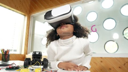 Chica creativa con auriculares VR para aprender en metaverso. Divertido niño disfrutar de usar auriculares AI y entrar en el programa de mundo virtual en la clase de tecnología STEM. Innovación. Estilo de vida futuro. Erudición.