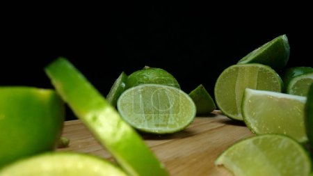 Photo for Close-up, a vibrant slice of fresh lime rests upon a rustic wooden cutting board, exuding freshness and vitality. The translucent membranes of the green lime slice placed on cutting board. Comestible. - Royalty Free Image
