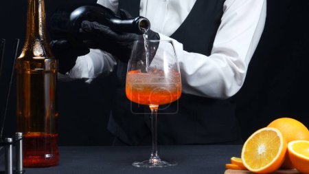 Makrographie, erleben Sie die geschickten Hände eines Barkeepers, wie sie vor auffallend schwarzem Hintergrund gekonnt einen Cocktail mixen. Jede Nahaufnahme fängt die fließende Bewegung und dynamische Energie ein. Komestibel.