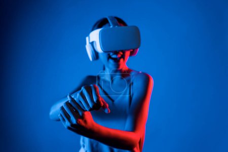 Photo for Smart female stand wear VR headset connecting metaverse, future cyberspace community technology. Elegant woman using hands controlling virtual laser saber seriously play fighting games. Hallucination. - Royalty Free Image