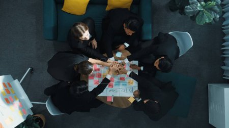 Photo for Top view of business people putting hands together and clapping hands to celebrate successful project while using kanban task board to manage time. Startup team stacking hands together. Directorate. - Royalty Free Image