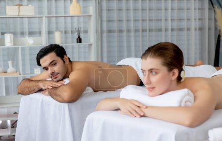 Foto de Cliente de pareja caucásica disfrutando de un relajante masaje de spa anti-estrés y mimándose con el ocio recreativo de belleza de la piel en el spa de salón ambiental de luz diurna en un resort de lujo u hotel. Silencioso. - Imagen libre de derechos