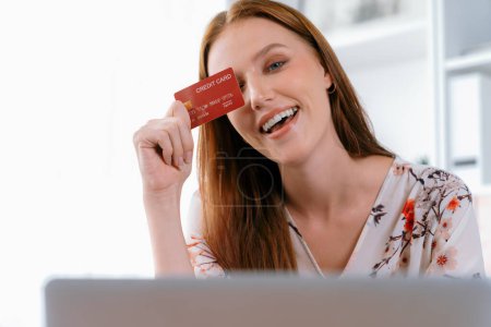 Photo for Young happy woman buy product by online shopping at home while ordering items from the internet with credit card online payment system protected by utmost cyber security from online store platform - Royalty Free Image