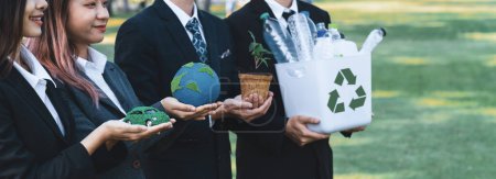 Photo for Group of businesspeople volunteer to promote Earth Day and environmental friendly, embracing ESG or Environmental, Social, and Governance practice to contribute greener environment sustainability.Gyre - Royalty Free Image