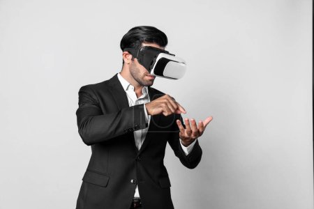 Foto de Inteligente hombre de negocios con traje sosteniendo algo mientras VR gafas para conectar metaverse. Gerente de proyecto profesional mirando holograma mediante el uso de auriculares de realidad visual. Innovación tecnológica. Desviación. - Imagen libre de derechos