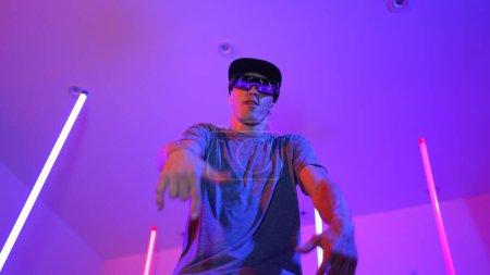 Photo for Low angle camera of caucasian dancer wearing fancy glasses and performing break dancing. Attractive man shown energetic performance and movement while looking at camera with confident. Regalement. - Royalty Free Image