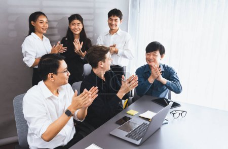 Photo for Diverse group of office worker and employee applauding, happily collaborate on strategic business marketing planning. Teamwork and positive attitude create productive and supportive workplace. Prudent - Royalty Free Image