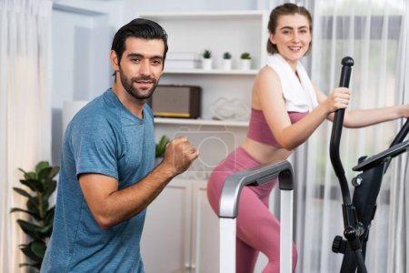 Photo for Athletic and sporty young couple or fitness buddy running on running machine together, home body workout exercise session as healthy sport lifestyle at home. Gaiety home exercise workout training. - Royalty Free Image