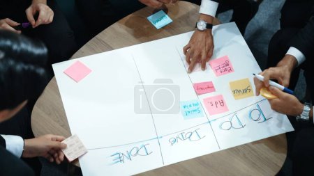 Photo for Top view of business people hands making scrum task board to manage workflow in workplace. Diverse marketing team drawing a line and use colorful stick notes to work on kanban. Close up. Directorate. - Royalty Free Image