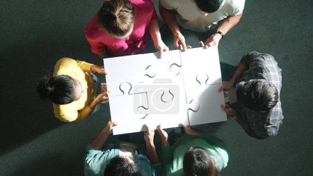 Photo for Top down view of business people gathering jigsaw together at meeting. Aerial view of diverse team collect or put piece of jigsaw puzzle together and standing while wearing casual cloth. Symposium. - Royalty Free Image