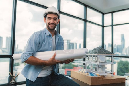 Photo for Portrait of professional architect engineer thinking about modern house project while wearing safety helmet and casual outfit. Smart interior designer holding project plans near house model. Tracery. - Royalty Free Image
