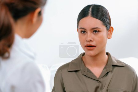Photo for Sad PTSD woman patient in uttermost therapy for mental health with psychologist, depression or grief after life failure. Frustrated trauma young woman talking to a psychologist about emotion in clinic - Royalty Free Image