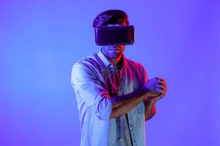 Foto de Hombre caucásico con gafas VR y gesto en movimiento sosteniendo la espada. Gamer utilizando futuros auriculares de realidad virtual digital o innovación futurista para entrar en el mundo meta o jugar juego de acción. Desviación. - Imagen libre de derechos