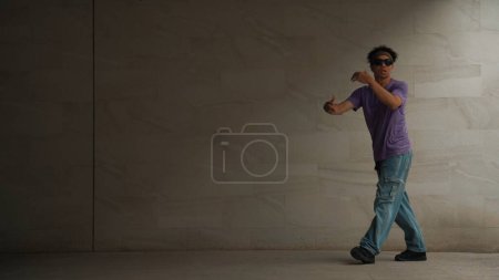 Photo for Skilled smart street dancer practice b-boy movement in building with gray background. Young handsome attractive choreographer perform energetic and active movement. Outdoor sport 2024. Sprightly. - Royalty Free Image