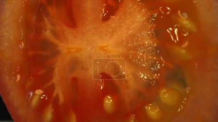 Téléchargez les photos : Macro photographie de tomates tranchées. La chair de tomate semble succulente et tendre, avec une légère fermeté. La tomate tranchée scintille sous la lumière, mettant en valeur leur fraîcheur et leur maturité. Comestible. - en image libre de droit