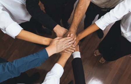 Photo for Group of diverse office worker join hand together in office room symbolize business synergy and strong productive teamwork in workplace. Cooperation and unity between business employee. Prudent - Royalty Free Image
