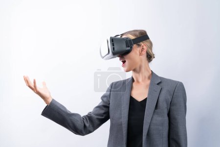 Téléchargez les photos : Femme d'affaires tenant quelque chose tout en portant un masque VR et debout à fond blanc. Gestionnaire de projet avec casque entrer dans la réalité visuelle programme mondial en utilisant l'innovation technologique. Machines et appareils. - en image libre de droit