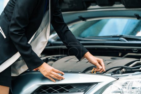 Téléchargez les photos : Une femme d'affaires dont la panne de voiture essayer de réparer la voiture par elle-même sans aide. uds - en image libre de droit