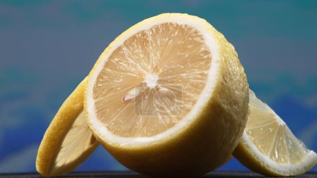 Una rodaja de limón, de color amarillo brillante y vibrantemente cítrico, se encuentra expuesto. La pulpa amarilla, con refrescante jugo, revela su interior segmentado. La esencia de la vitalidad cítrica. En cámara lenta. Comestible.