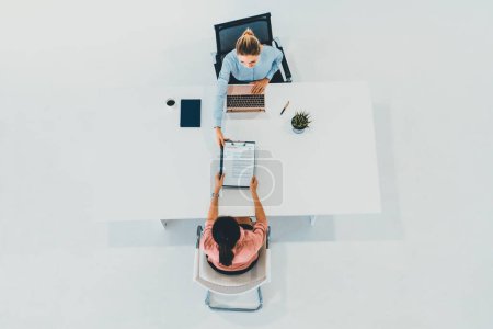 Photo for Two young business women in meeting at office table for job application and business agreement. Recruitment and human resources concept. uds - Royalty Free Image