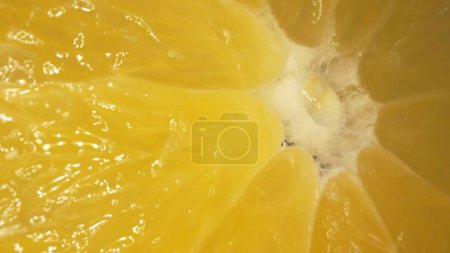 Photo for The macro photography of a sliced orange with vibrant orange color and visible in the juicy flesh of the citrus fruit. The flesh of the orange appears plump, hinting at its juiciness. Comestible. - Royalty Free Image