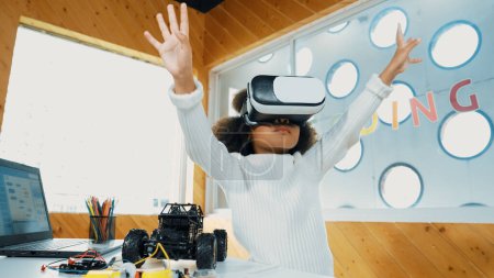 Kreative Mädchen tragen VR-Headset zum Lernen in Metaverse. Lustige Kinder genießen es, KI-Headset zu tragen und in der MINT-Klasse in die virtuelle Welt einzutreten. Innovation. Zukünftiger Lebensstil. Erution.