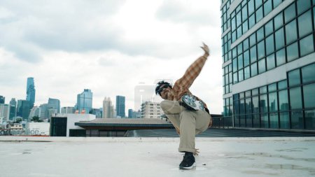Glückliche hispanische Tänzerin trägt lässiges Outfit Breakdance in urbaner Stadt. Energetische Hip-Hop-Performance. Choreographen bewegen sich im Freestyle-Takt. Hip-Hop-Tanz. Outdoor-Sport 2024. Vorfreude.