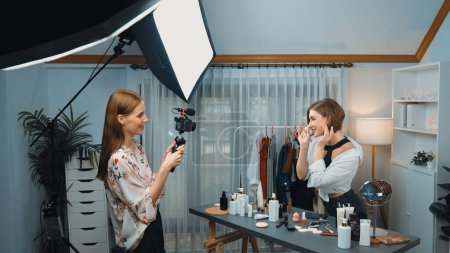 Photo for Two women influencer partner shoot live streaming vlog video review skincare for prim social media or blog. Young girl with cosmetic studio lighting for marketing recording session broadcasting online - Royalty Free Image