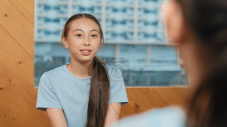 Photo for Young smart girl discussion about problem while sitting in circle. Skilled happy highschool student talking, brainstorming, sharing idea while diverse children listen and give comment. Edification. - Royalty Free Image