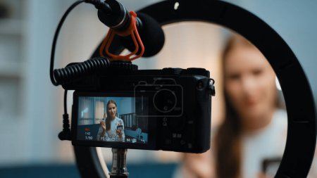 Photo for Rear view behide camera screen display influencer shoot live streaming vlog video review makeup prim social media or blog. Girl with cosmetics studio lighting for marketing recording session online. - Royalty Free Image