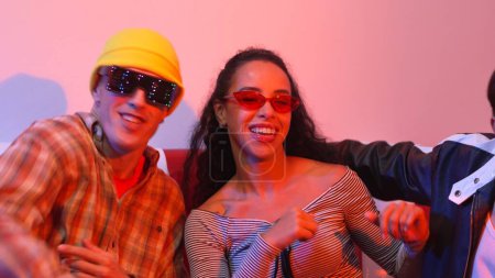 Photo for Close up of asian man and hispanic woman dancing together at party with led or neon light. Professional street dancer moving to freestyle and lively music while wear glasses and cloth. Regalement. - Royalty Free Image