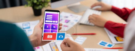 Photo for Panorama banner of startup UX developer or company employee design user interface or UI prototype for mobile application or website software with software display on smartphone in office. Synergic - Royalty Free Image