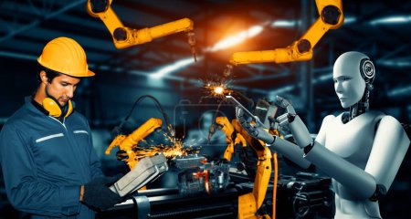 Téléchargez les photos : MLP Robot industriel mécanisé et travailleur humain travaillant ensemble dans la future usine. Concept d'intelligence artificielle pour la révolution industrielle et l'automatisation des processus de fabrication. - en image libre de droit